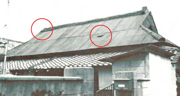 写真:左側の鬼瓦が撃ち落とされた。穴が開いた屋根はトタンで修繕