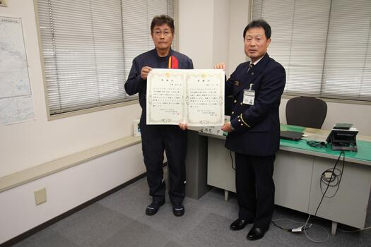 当日欠席の志摩様、森本様の代理で表彰された猪熊（いのくま）様と北消防署長の写真