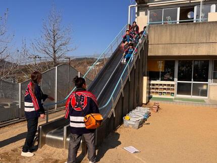 避難器具のすべり台で迅速に避難する園児の写真