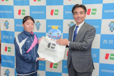 大学カヌー部前主将の吉田奈未さんと石井市長との記念写真