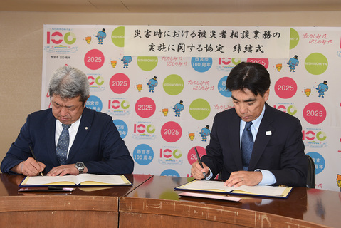 協定書に署名する石井市長と野上英則会長
