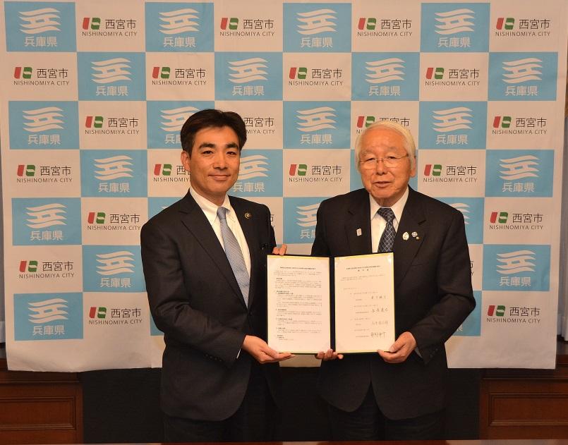 締結書を井戸県知事と石井市長が交換した際の記念写真