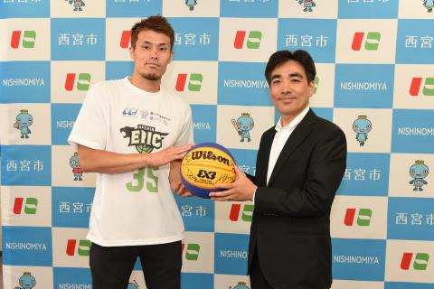 石井市長へ選手たちのサイン入りのバスケットボールを渡す様子